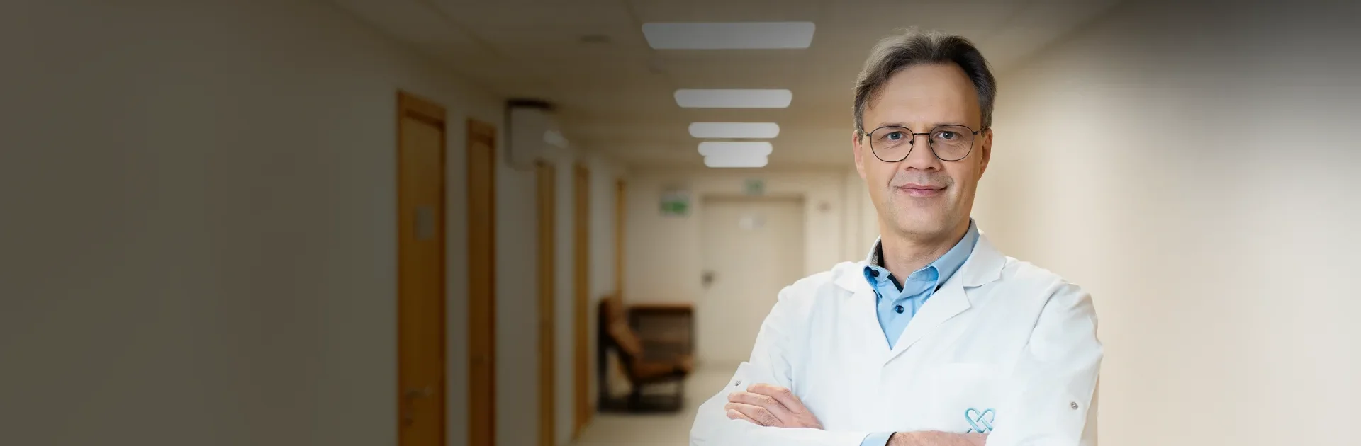 Gydytojas ortopedas traumotologas stovi klinikos koridoriuje